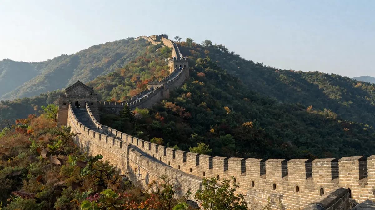 The Great Wall winding over green mountains on a clear morning
